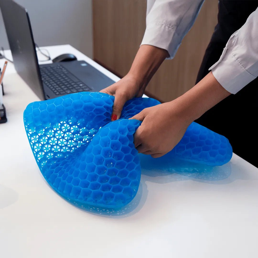 Almofada de assento ergonômica em gel de silicone com estrutura em favo de mel, projetada para absorção de impacto, distribuição de peso e alívio de pressão no cóccix, desenvolvido com tecnologia de gel refrescante e espuma viscoelástica para adaptação perfeita aos contornos do corpo.