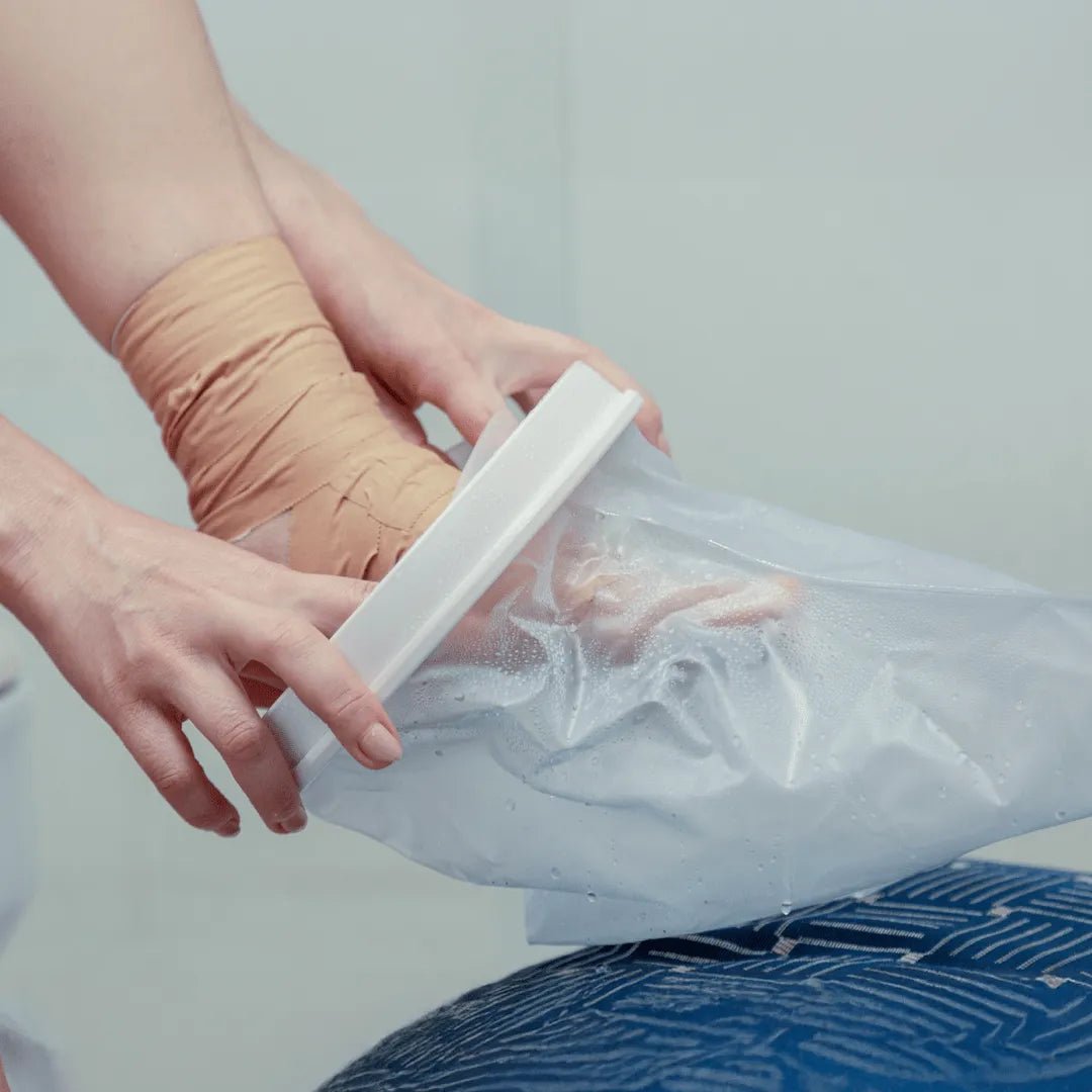 Protetor impermeável para pé e tornozelo, projetado com sistema de vedação sem compressão excessiva para proteção hídrica pós-cirúrgica, desenvolvido com foco na praticidade do cuidador e na proteção e alívio contínuo do paciente.
